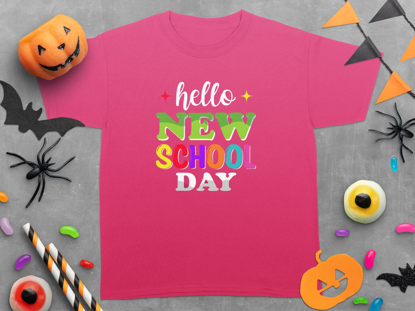 Pink t-shirt with "hello NEW SCHOOL DAY" in colorful text and Halloween decorations.
