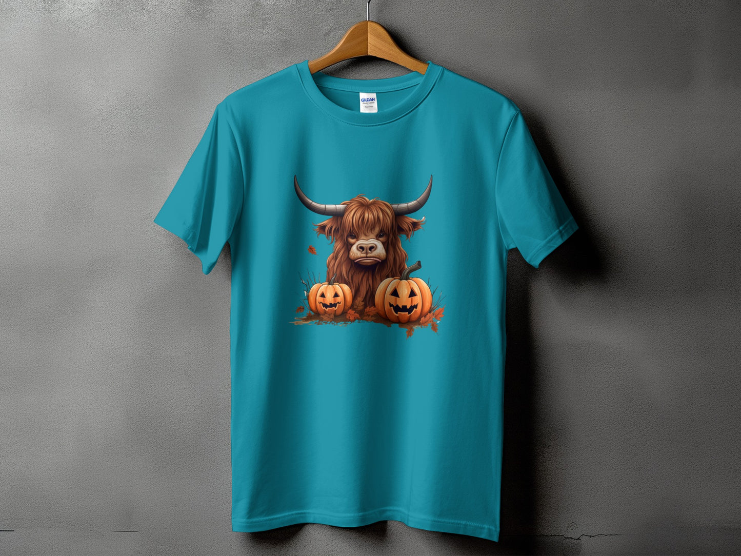Teal t-shirt with Highland cow and jack-o'-lanterns Halloween graphic.