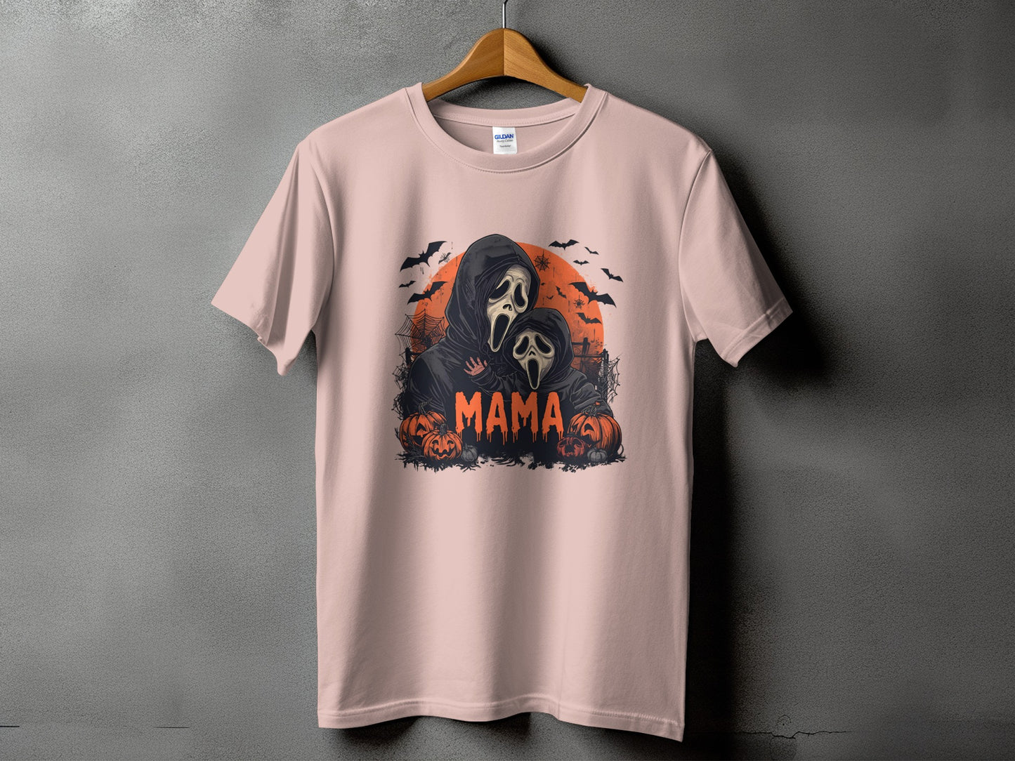 Pink t-shirt with a Halloween graphic of two ghost-masked figures and the word "MAMA".