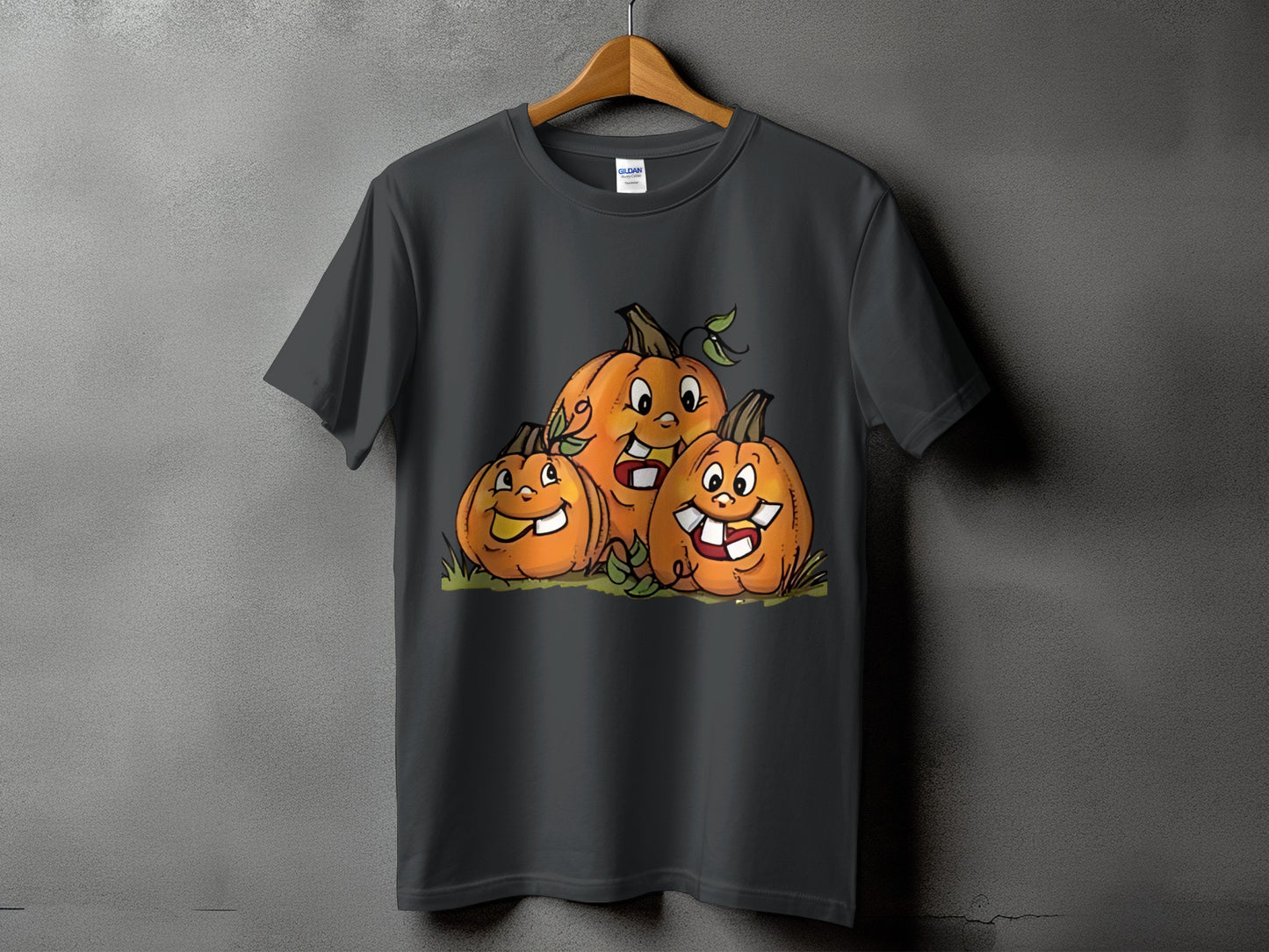 Three cartoon pumpkins with smiling faces and teeth on a dark gray t-shirt.