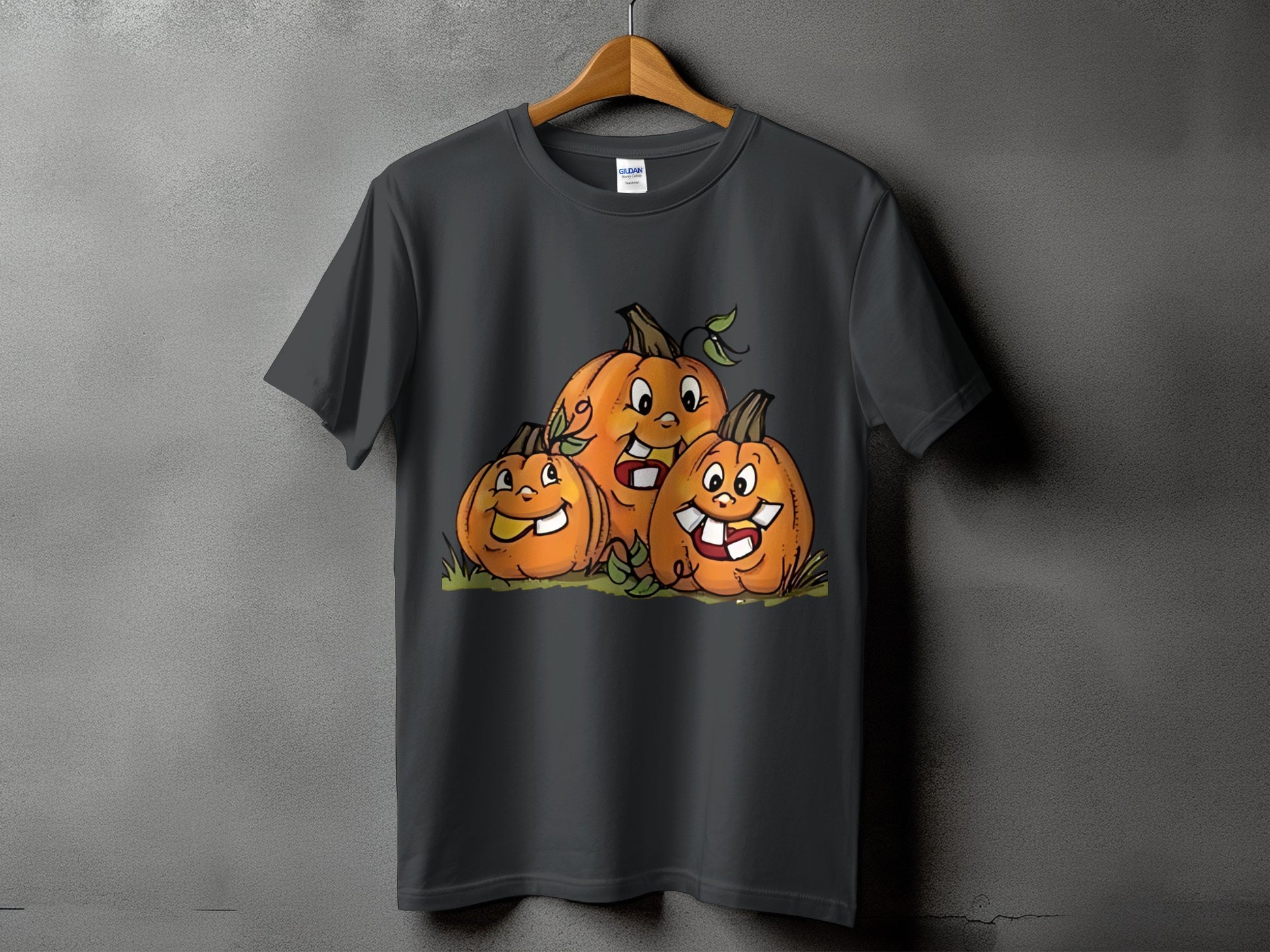 Three cartoon pumpkins with smiling faces and teeth on a dark gray t-shirt.
