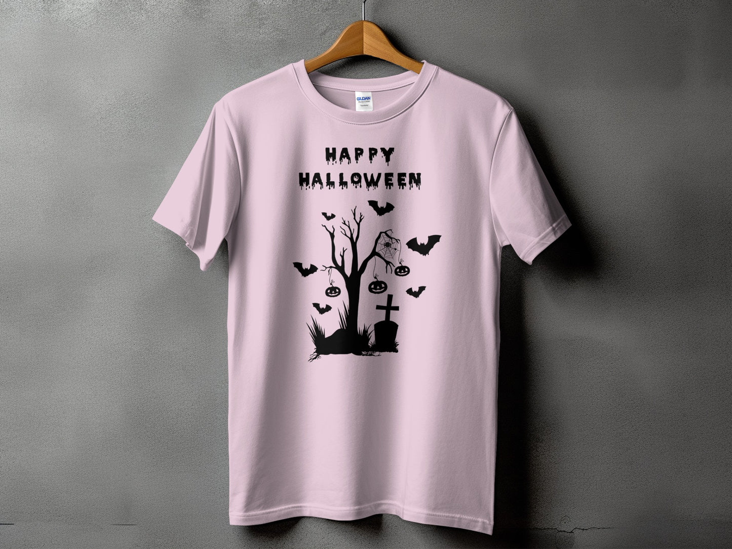Pink t-shirt with black Halloween graphic featuring text, a tree, bats, and pumpkins.