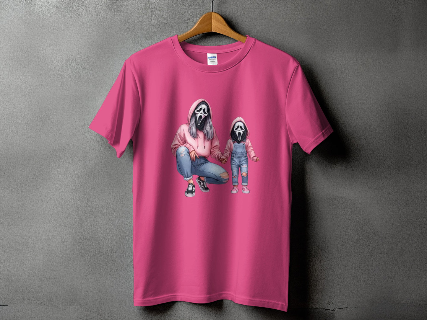 Pink t-shirt with graphic of two ghost-faced figures in hoodies and overalls.