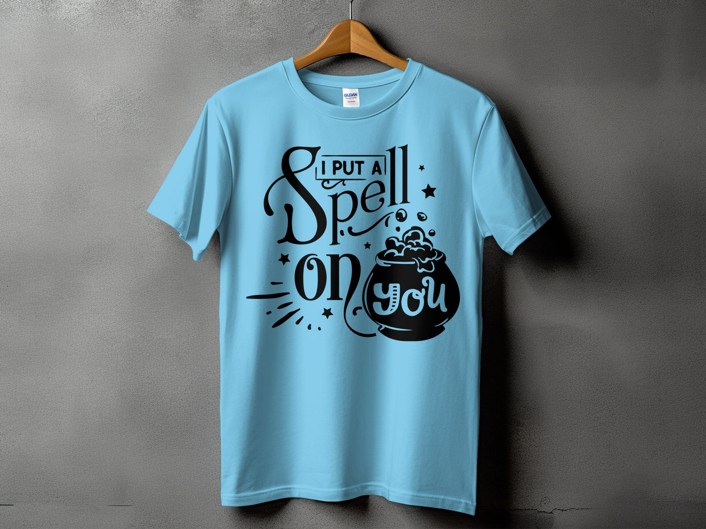 Light blue t-shirt with black text "I PUT A Spell ON YOU" and a cauldron.