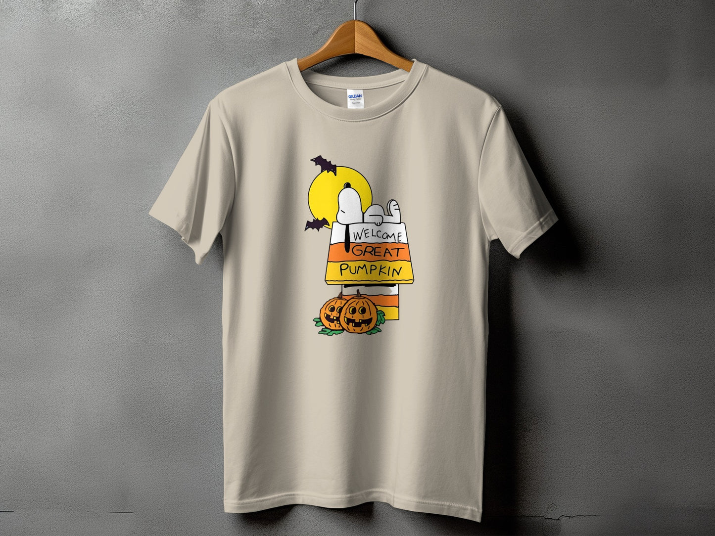 Tan t-shirt with Snoopy, pumpkins, and bats under a yellow moon.
