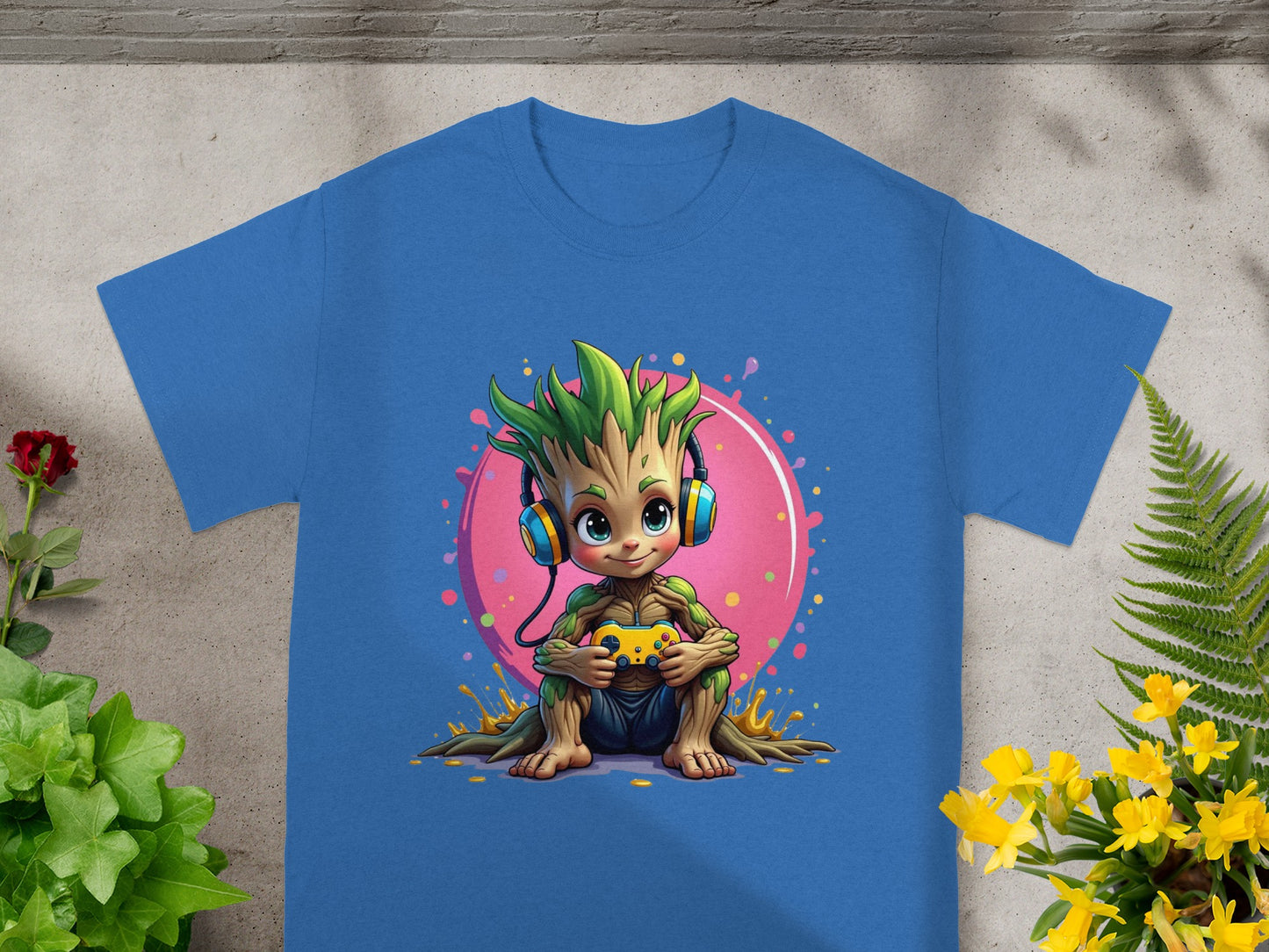 Groot character in headphones holding video game controller on blue t-shirt.