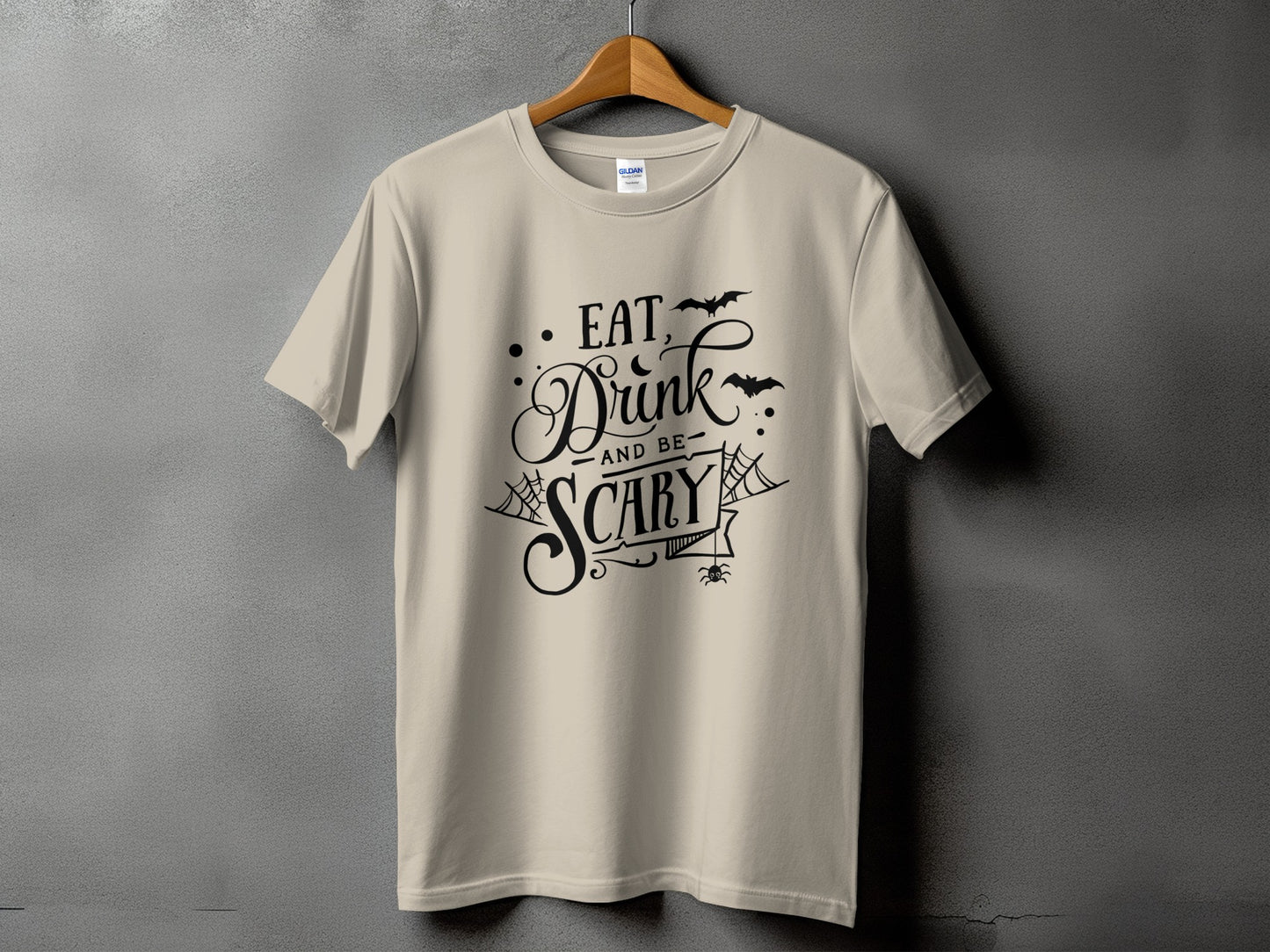 Cream t-shirt with black Halloween text "Eat, Drink and be Scary" and graphics.