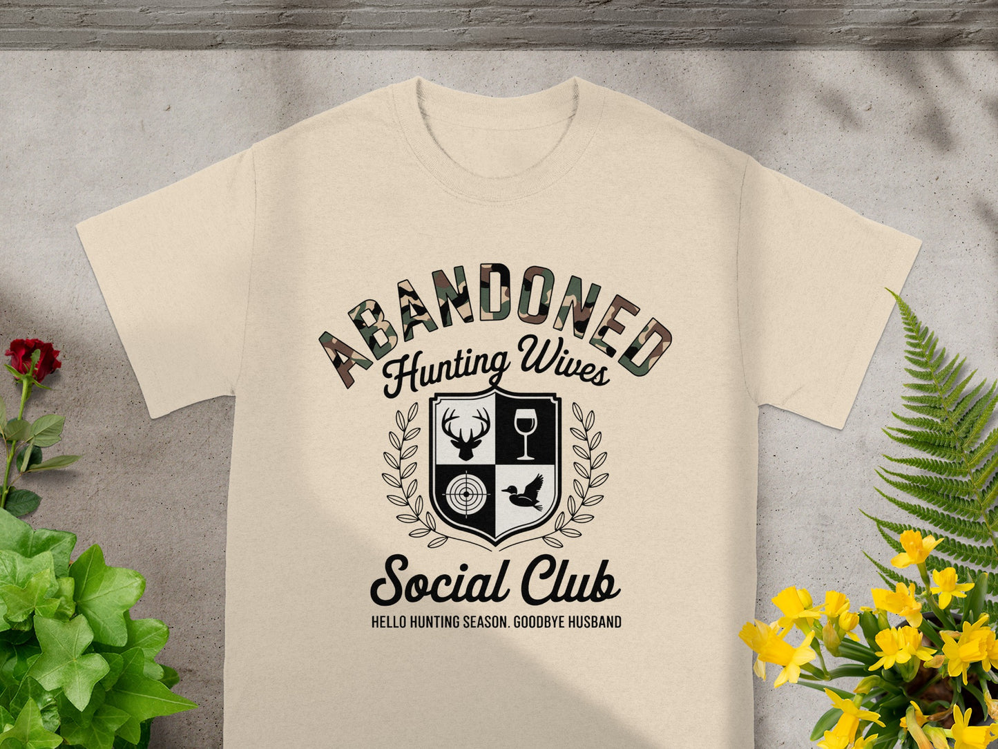 Cream t-shirt with "Abandoned Hunting Wives Social Club" and hunting graphics.