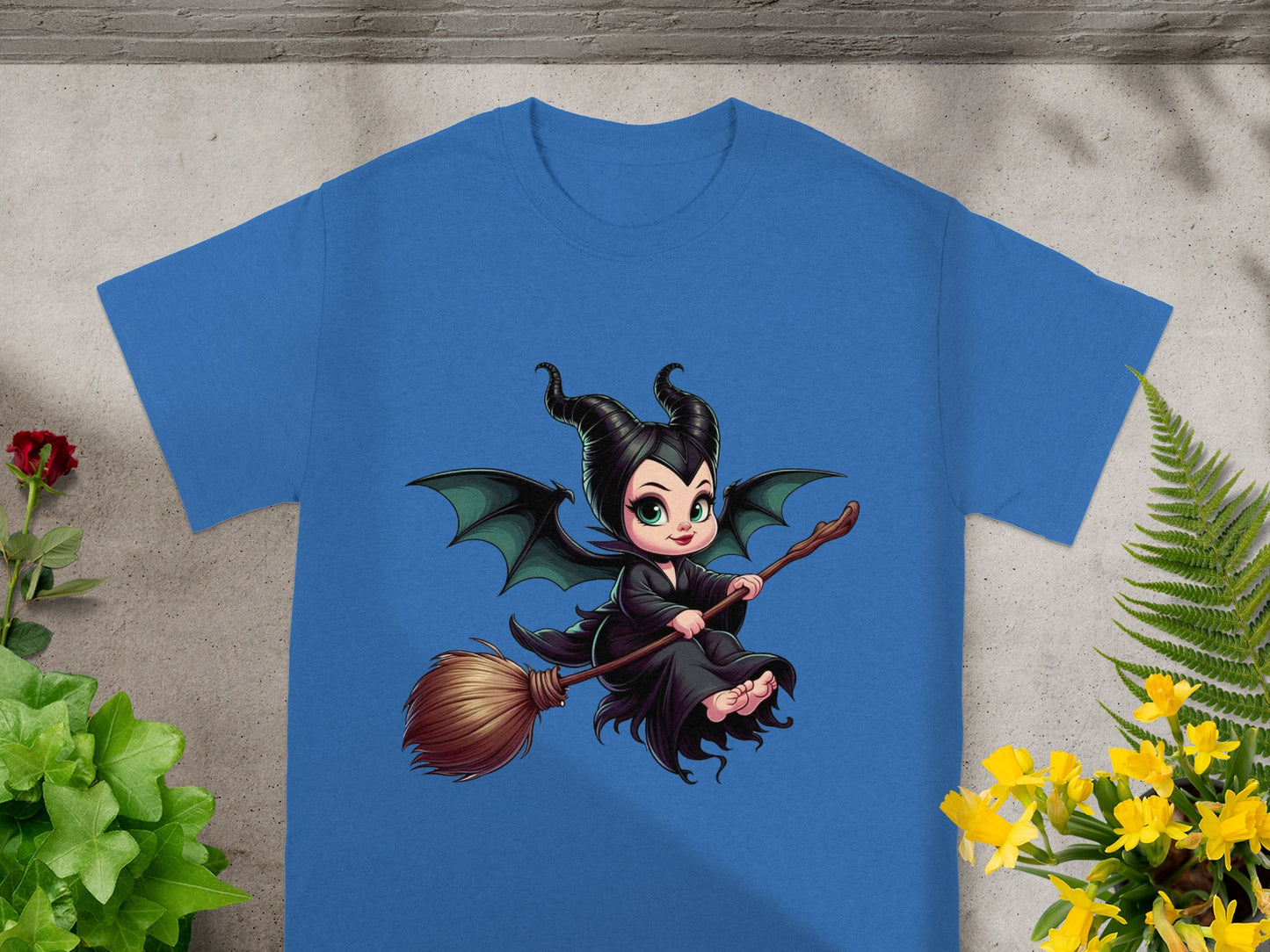 Blue t-shirt with cartoon Maleficent flying on a broomstick.