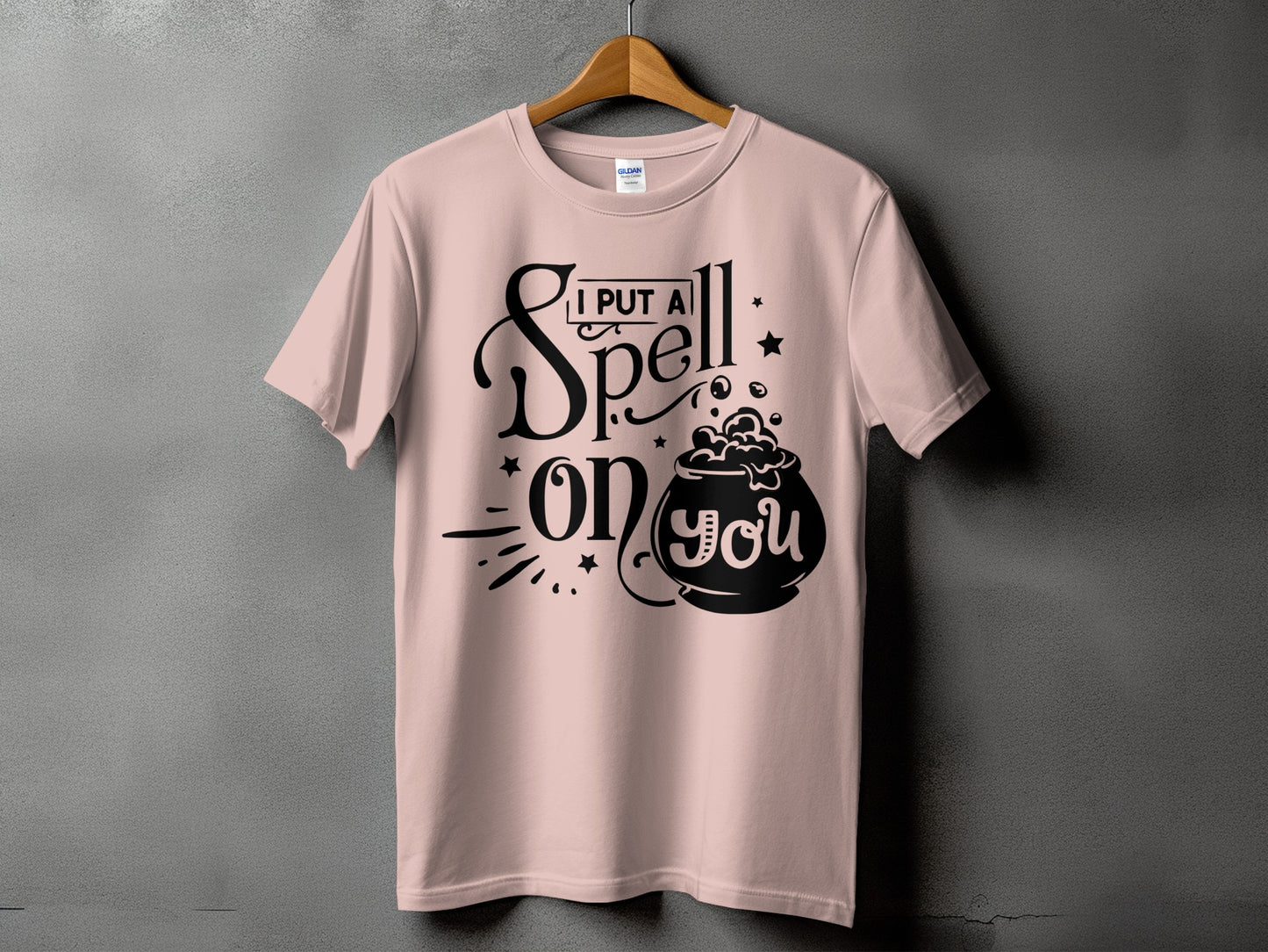 Light pink t-shirt with black text "I PUT A Spell on you" and a cauldron.