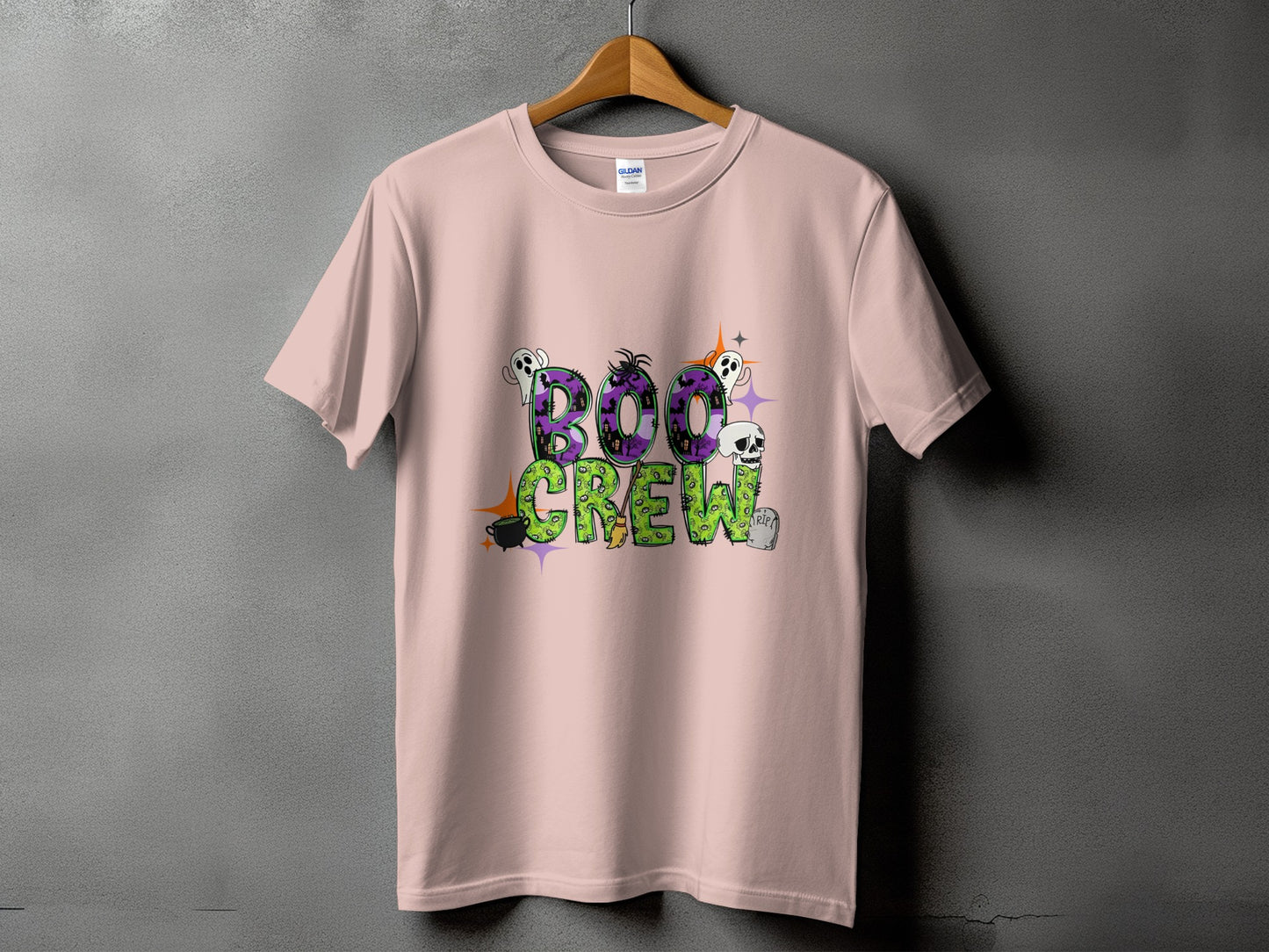 Pink t-shirt with "Boo Crew" Halloween graphic featuring ghosts, skull, and cauldron.