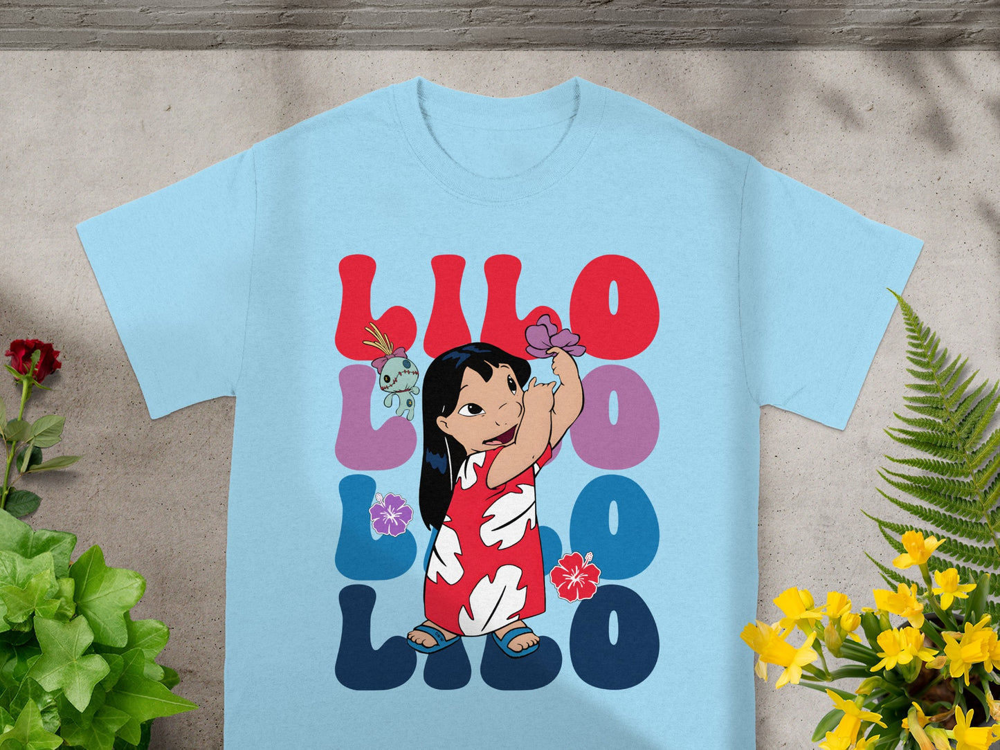 Light blue t-shirt with Lilo and Stitch cartoon graphic and colorful text.