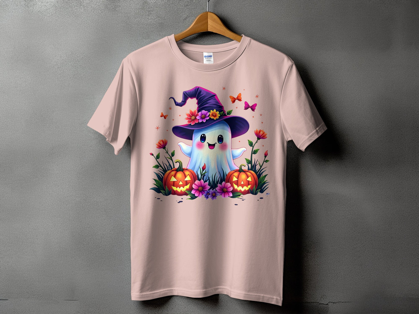 Pink t-shirt with a cute ghost wearing a witch hat, pumpkins, and flowers.