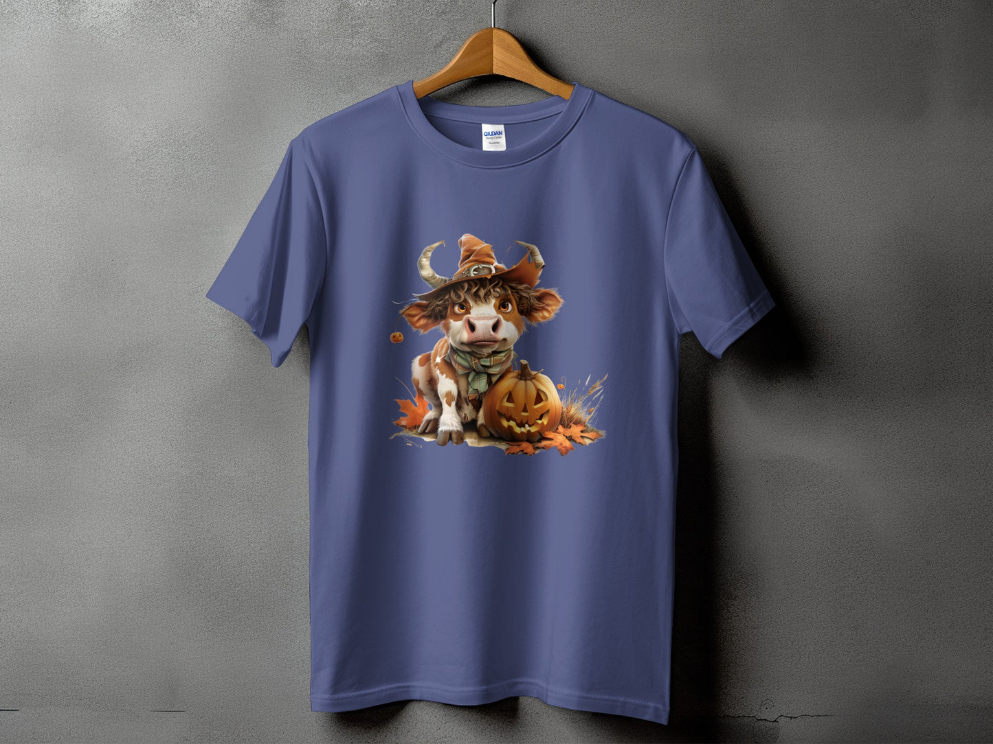 Cow in witch hat with pumpkin and autumn leaves graphic on a purple t-shirt.