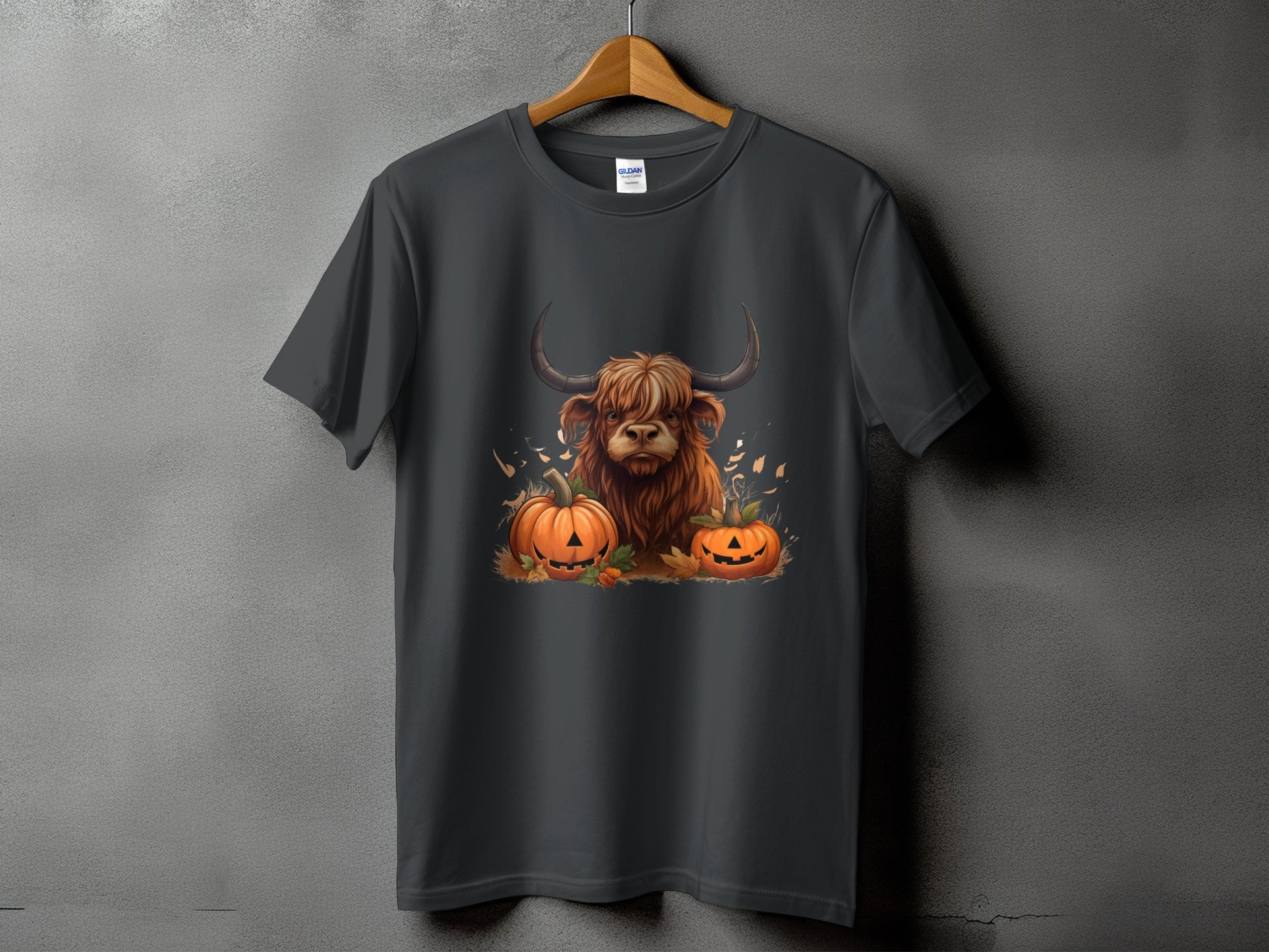 Dark gray t-shirt featuring a Highland cow with pumpkins and fall leaves graphic.
