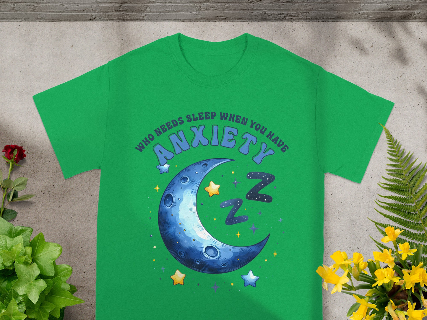 Green t-shirt with quote "Who needs sleep when you have anxiety" and moon graphic.