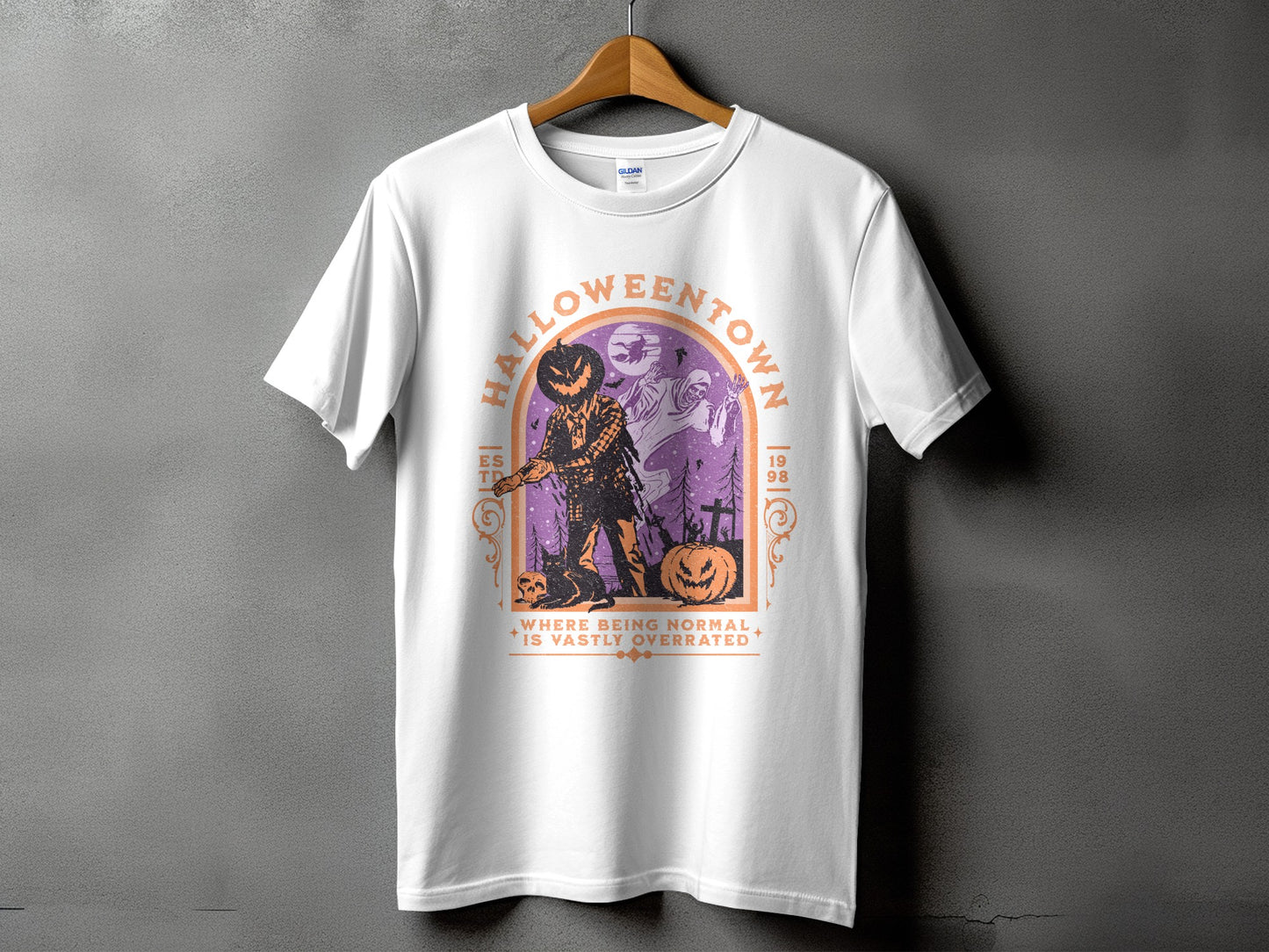 White t-shirt with Halloween design featuring a jack-o'-lantern scarecrow and ghosts.