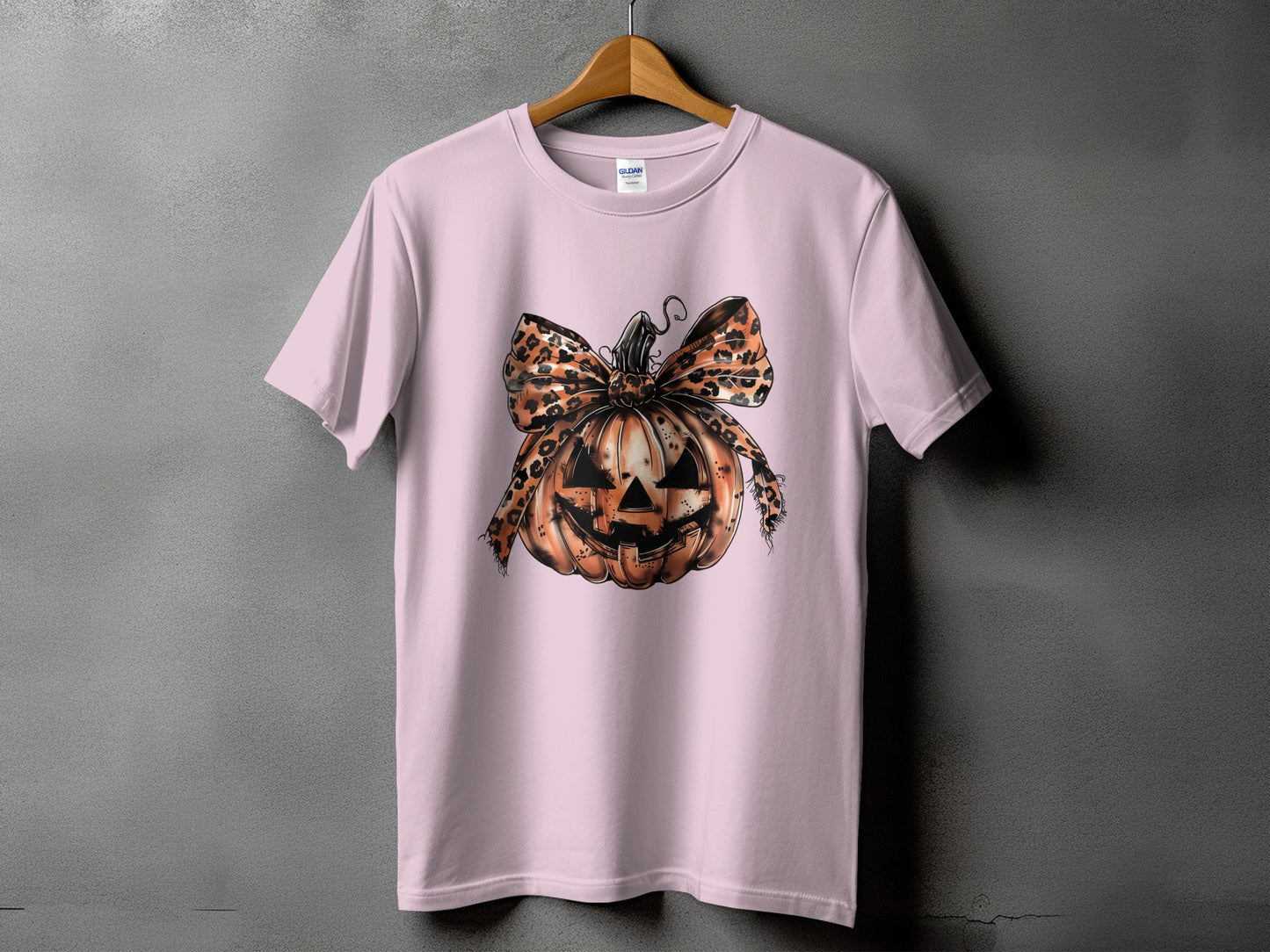 Pink t-shirt with a Jack-o'-lantern design and leopard print bow.