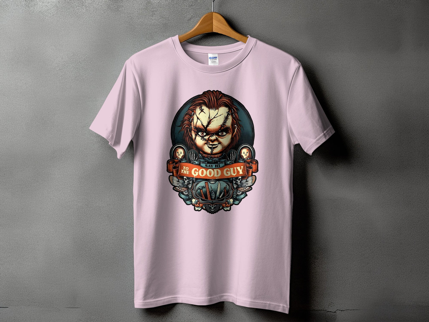 Pink t-shirt with Chucky's face and the text "TO THE GOOD GUY SAY HI".