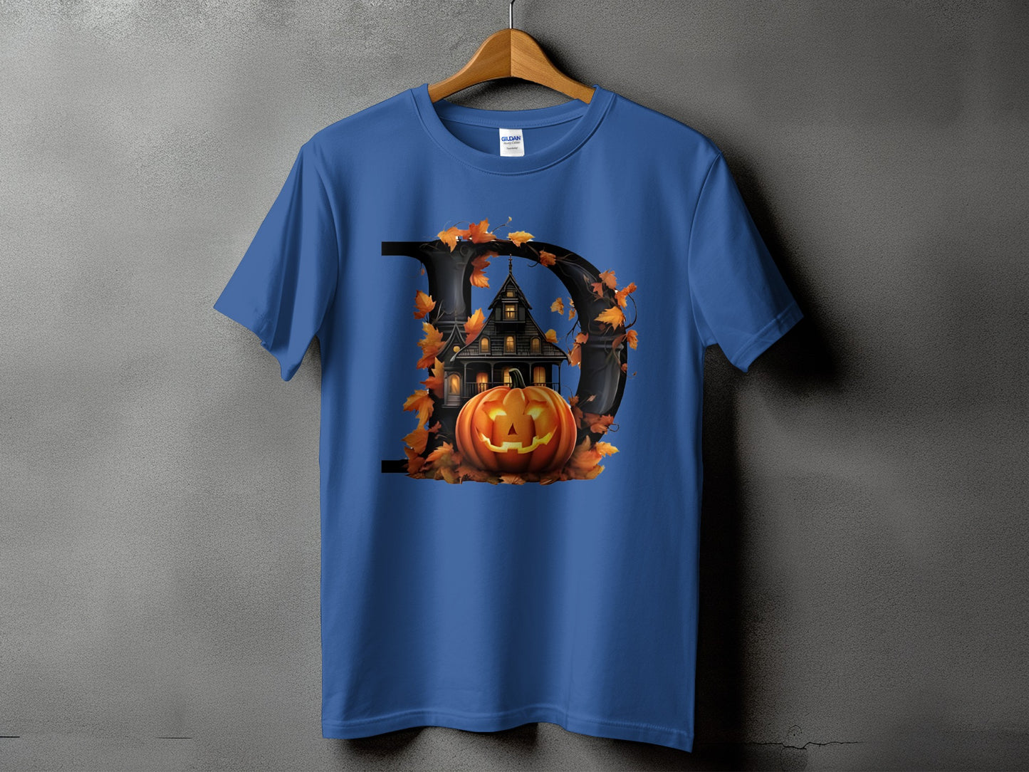 Blue t-shirt with a black letter D featuring a haunted house and jack-o'-lantern.