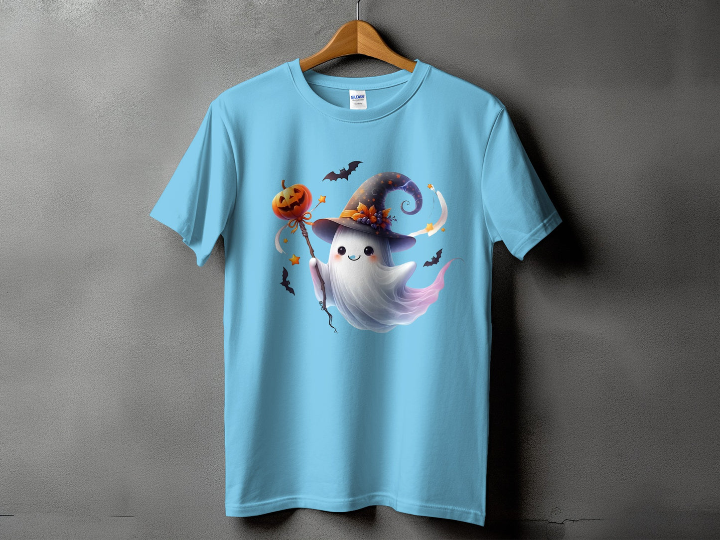 Light blue t-shirt with a cartoon ghost in a witch hat holding a pumpkin on a stick.