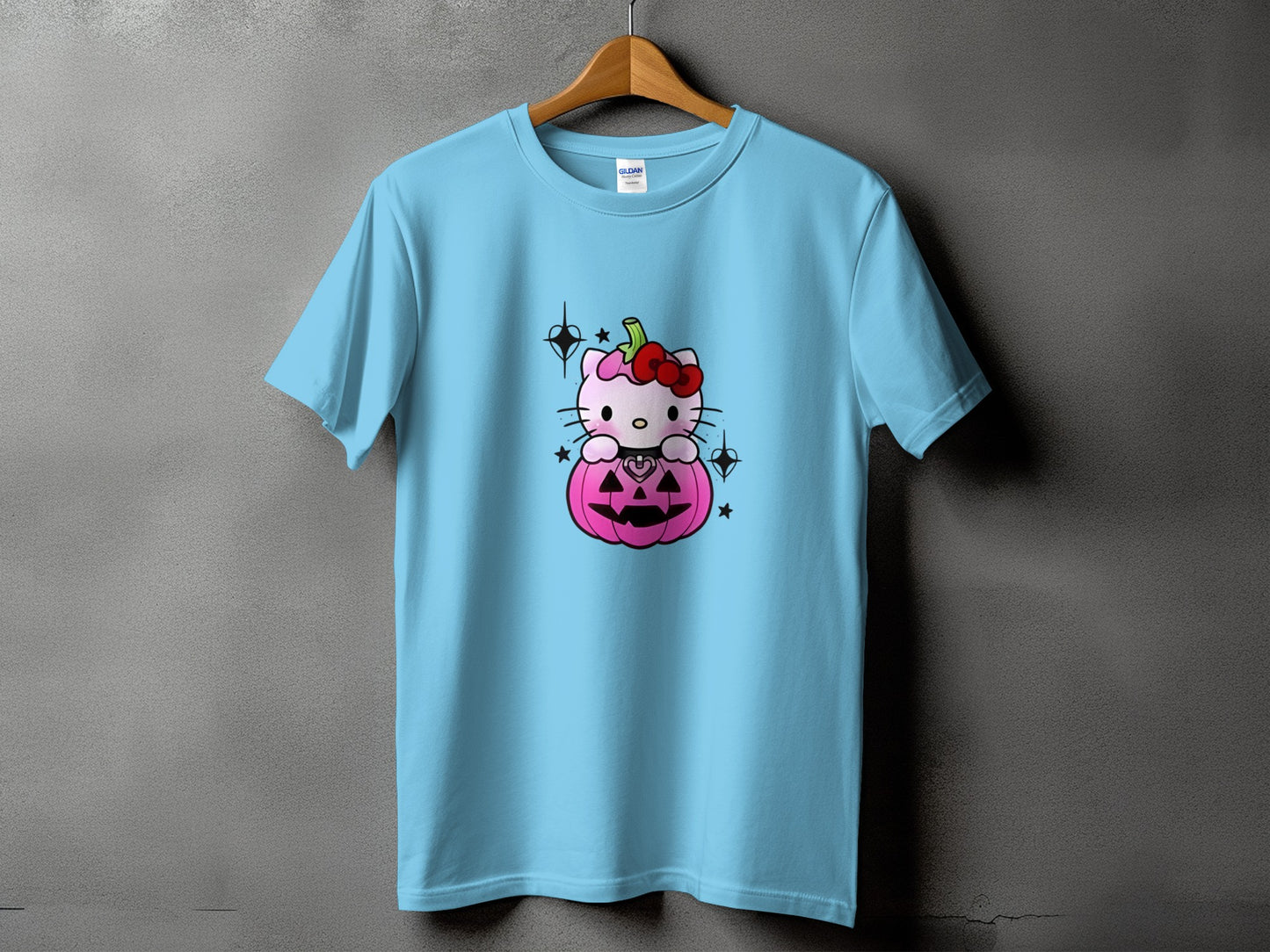Light blue t-shirt with a pink Hello Kitty sitting in a pink pumpkin.