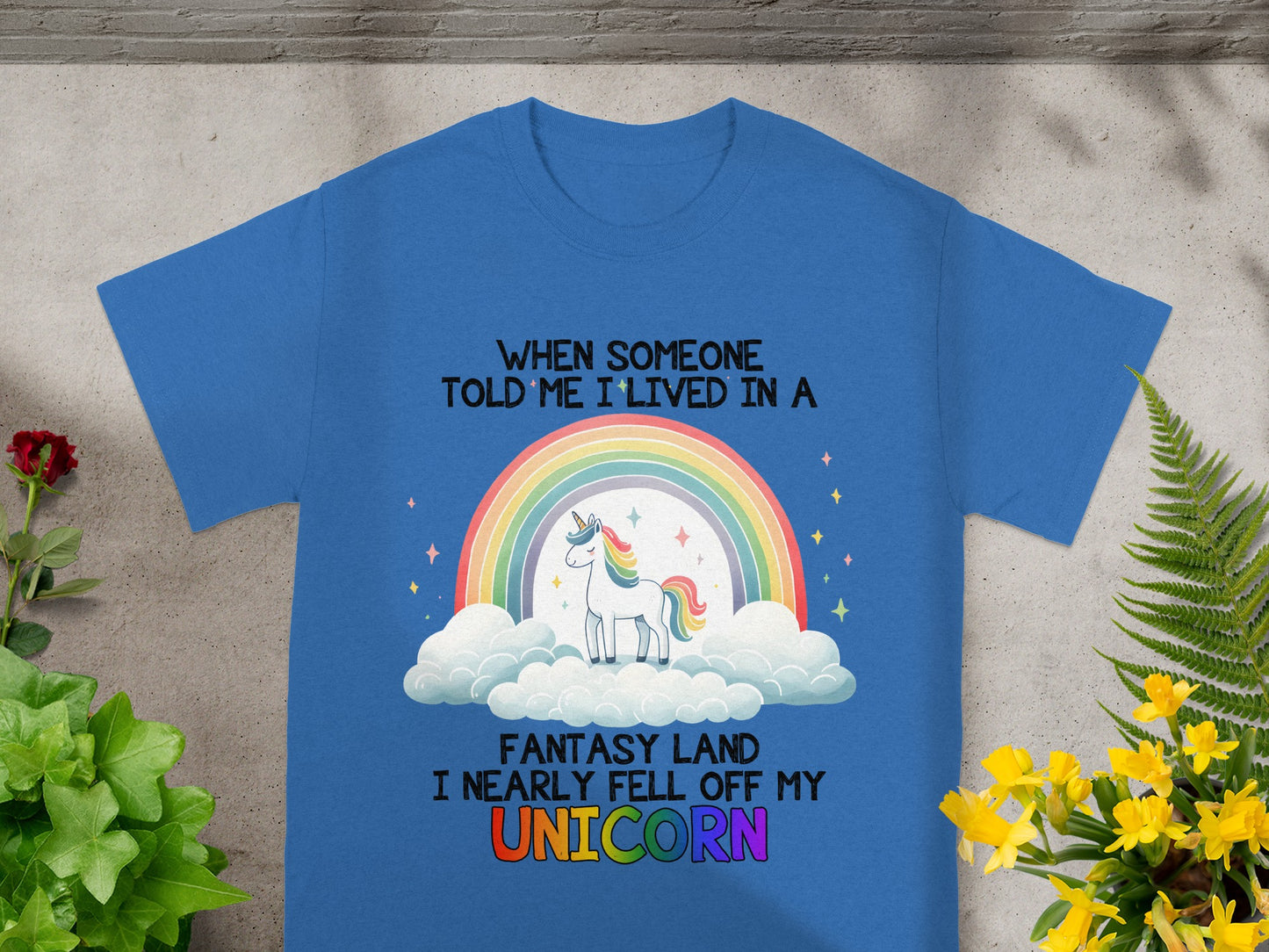 Blue t-shirt with text and a unicorn on a rainbow and clouds.