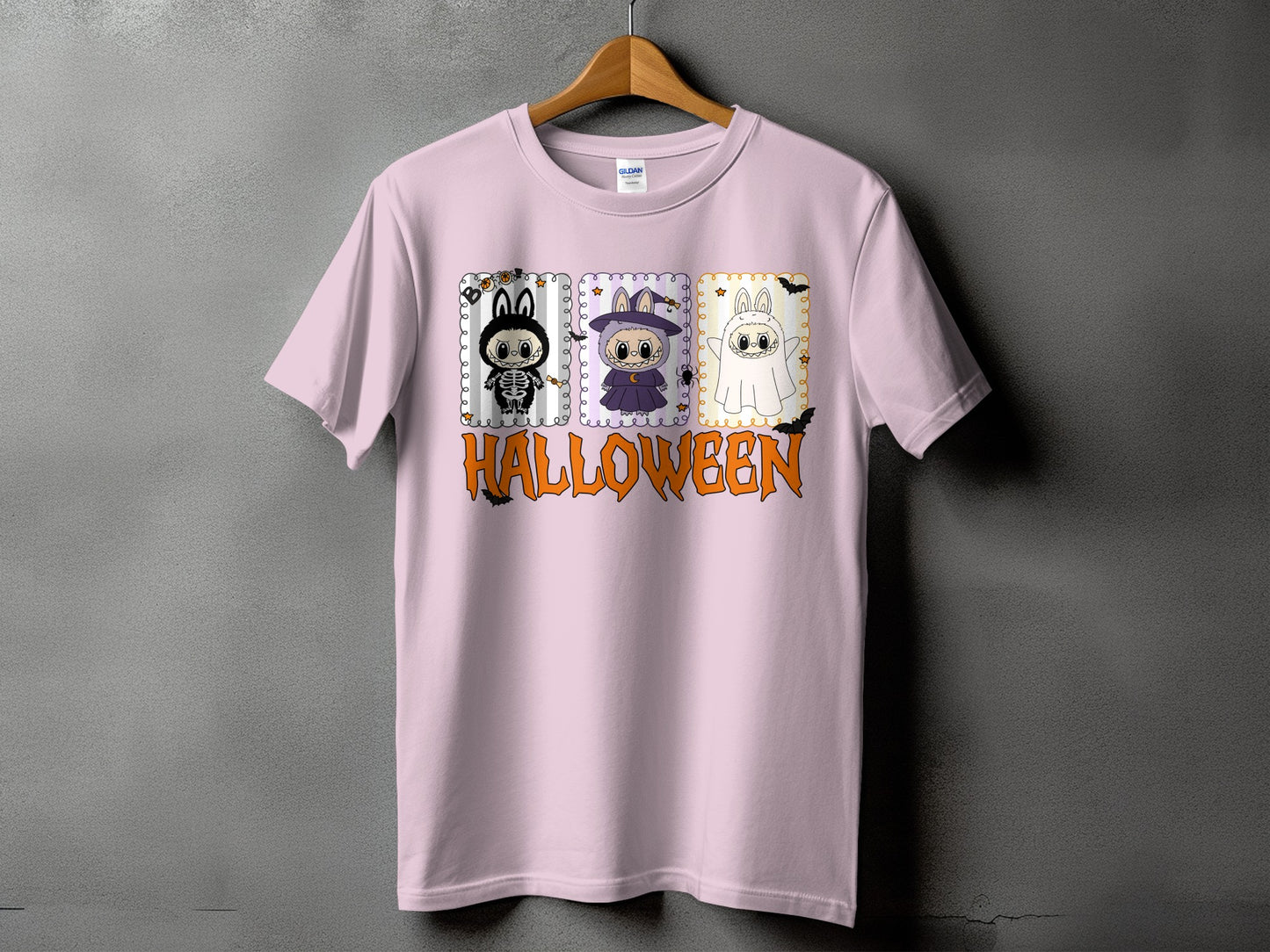Pink t-shirt with Halloween graphic featuring three cartoon characters and text.