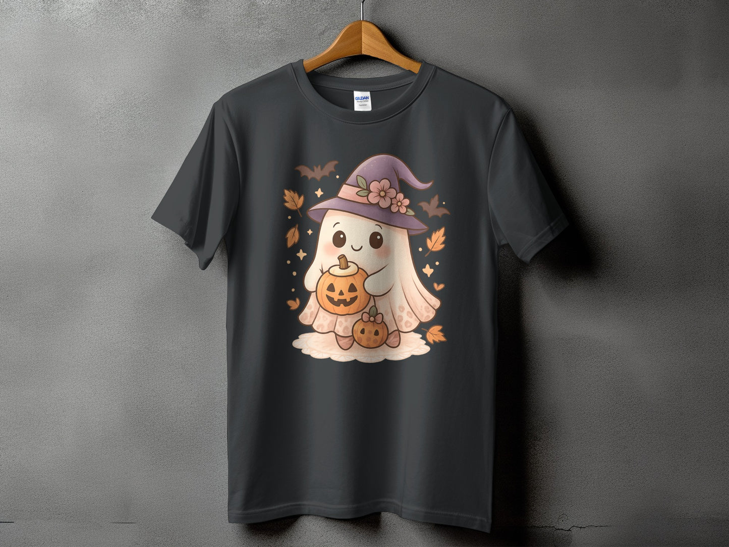 Dark grey t-shirt with cartoon ghost wearing witch hat holding pumpkins and surrounded by bats.