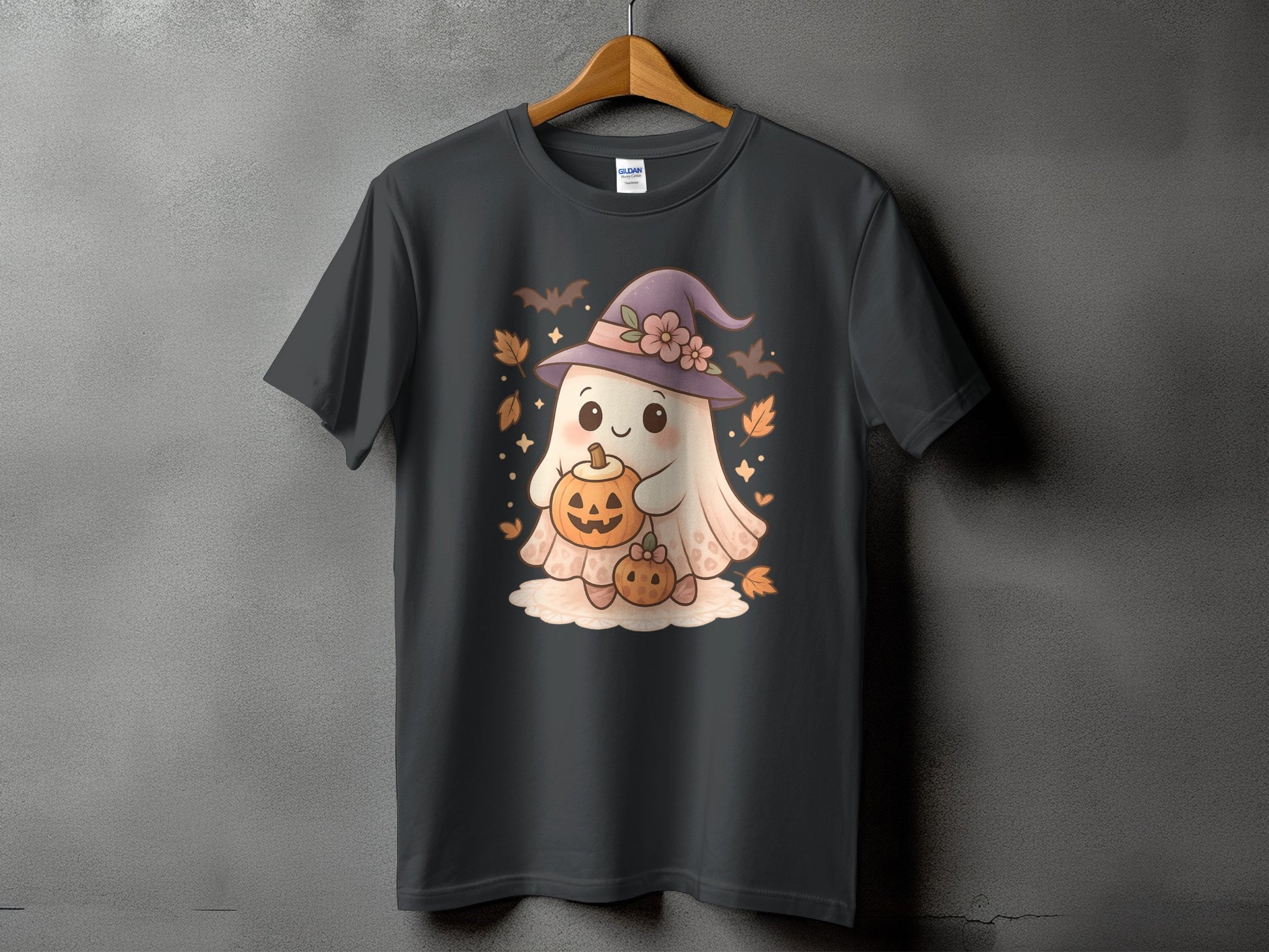 Dark grey t-shirt with cartoon ghost wearing witch hat holding pumpkins and surrounded by bats.