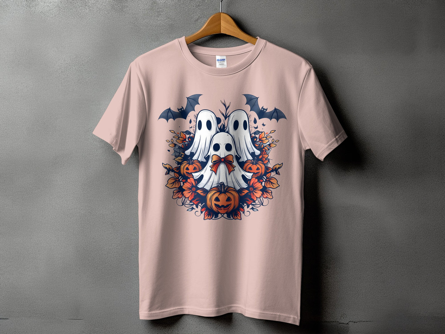Pink t-shirt with Halloween design of three ghosts, pumpkins, bats, and foliage.