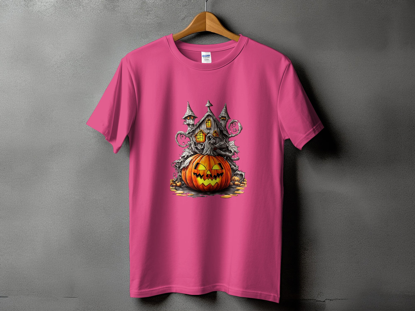 Pink t-shirt with a Halloween graphic of a haunted house and a jack-o'-lantern.