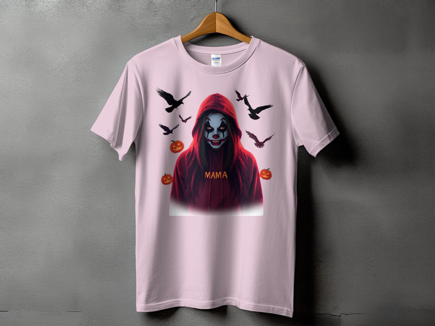 Pink t-shirt with a spooky clown design, text "MAMA", and surrounding crows and pumpkins.