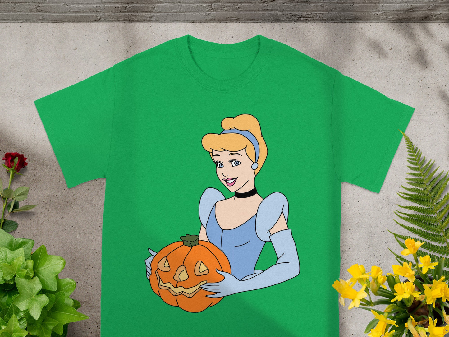 Cinderella wearing blue dress holding a jack-o'-lantern on a green t-shirt.