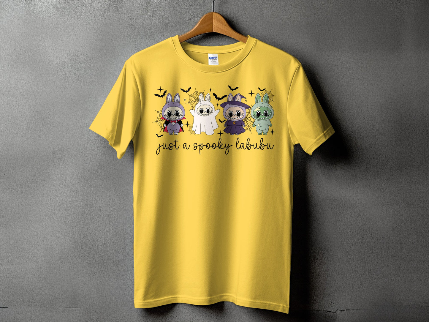 Yellow t-shirt with four Halloween-themed cartoon bunnies and "just a spooky labubu" text.