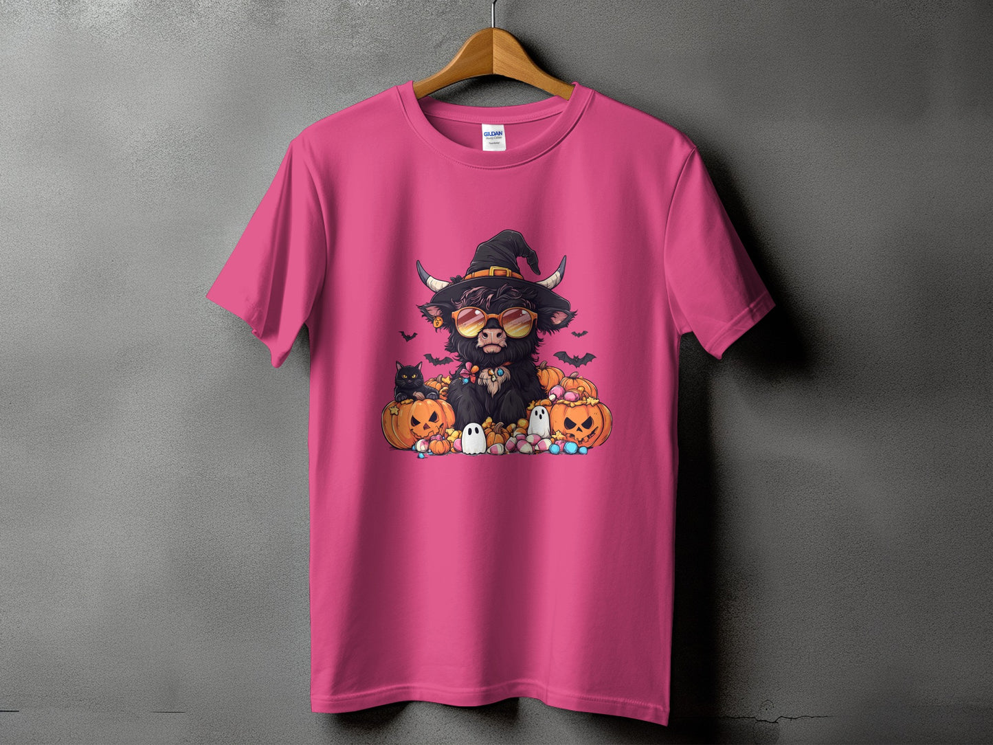 Halloween Highland cow with pumpkins, black cat, and ghosts on a pink t-shirt.