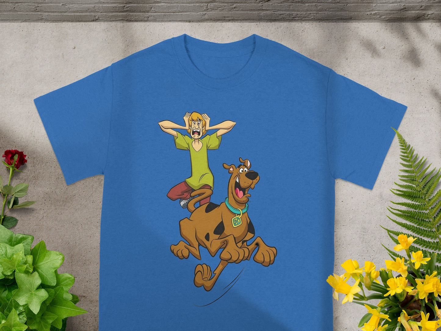 Scooby-Doo and Shaggy running from something, printed on a blue t-shirt.