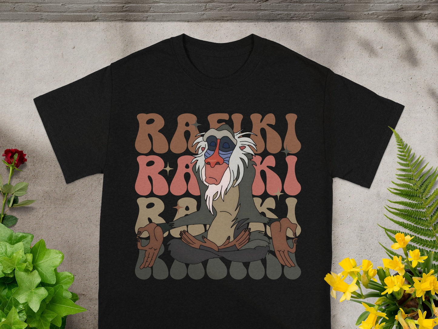 Black t-shirt with Rafiki meditating, surrounded by colorful text.