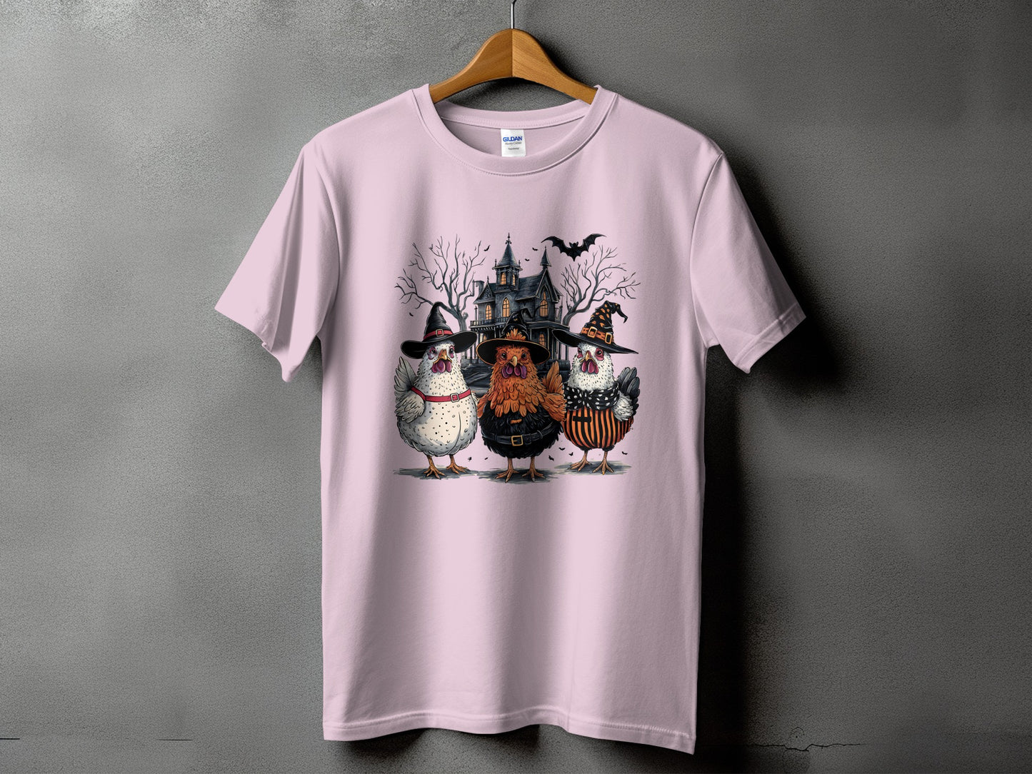 Three chickens wearing witch hats and costumes in front of a haunted house.