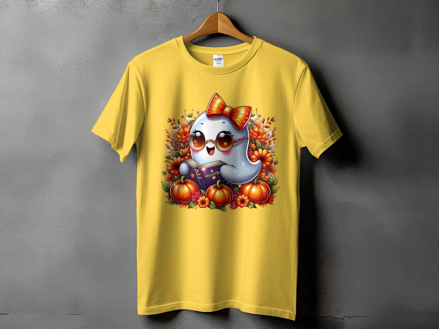 Yellow t-shirt with a cute ghost reading a book with pumpkins and flowers.