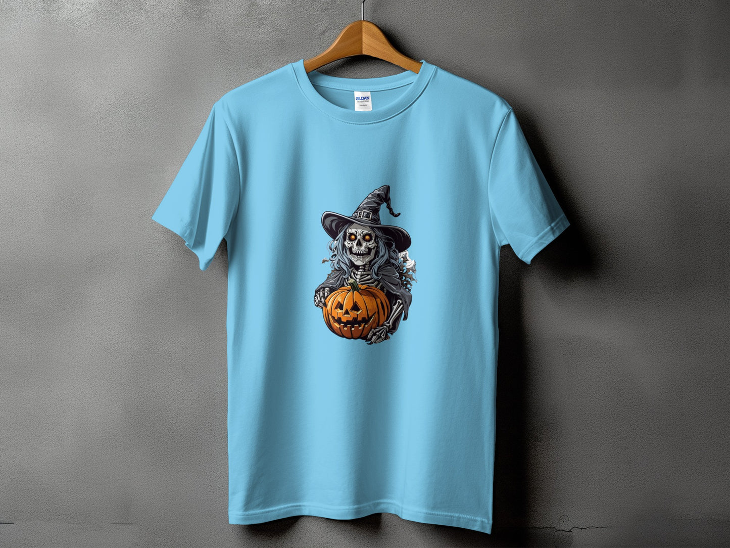 Light blue t-shirt with a skeleton in a witch hat holding a pumpkin graphic.