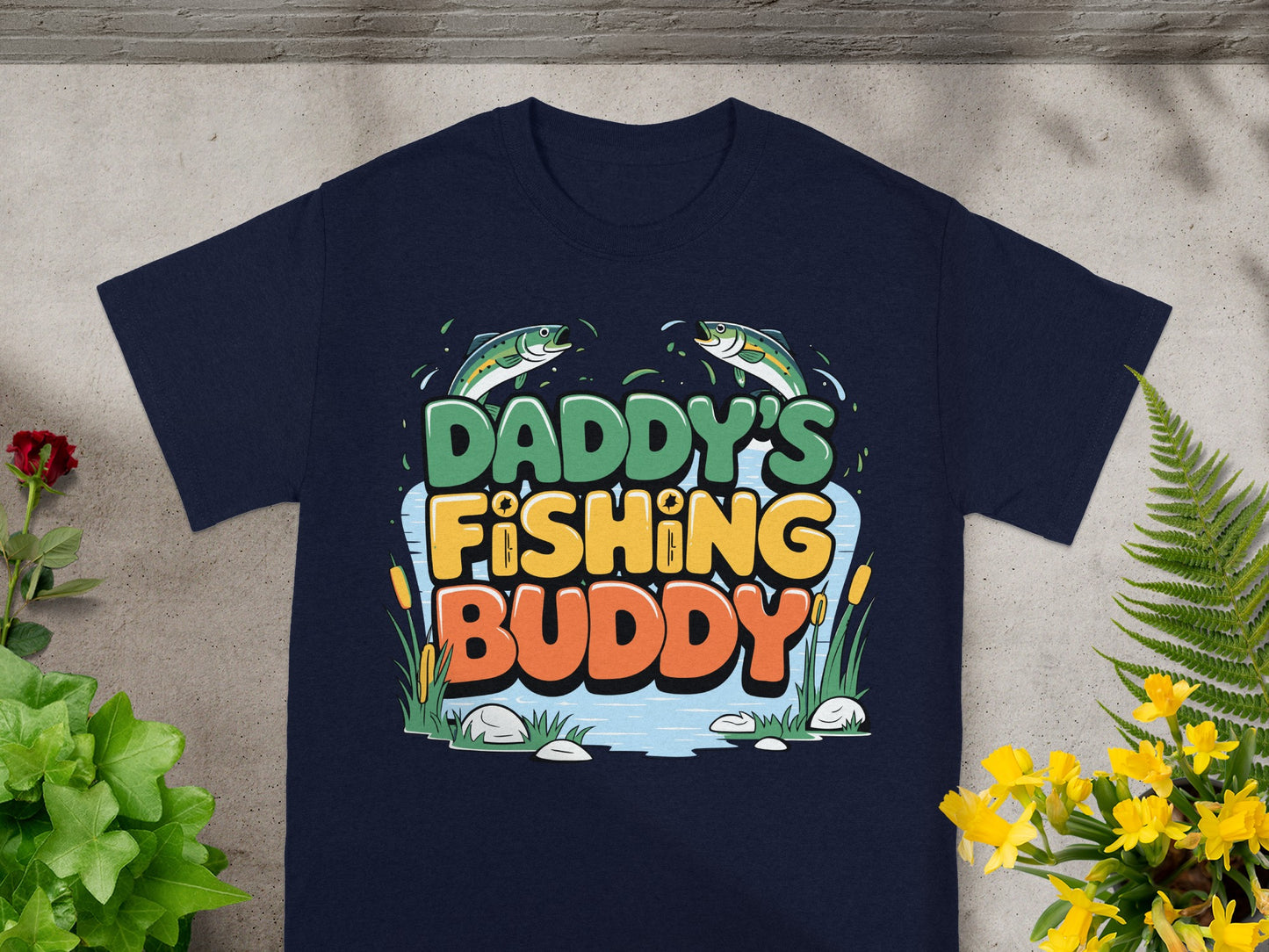 Daddy's Fishing Buddy text with fish and water graphic on navy t-shirt.