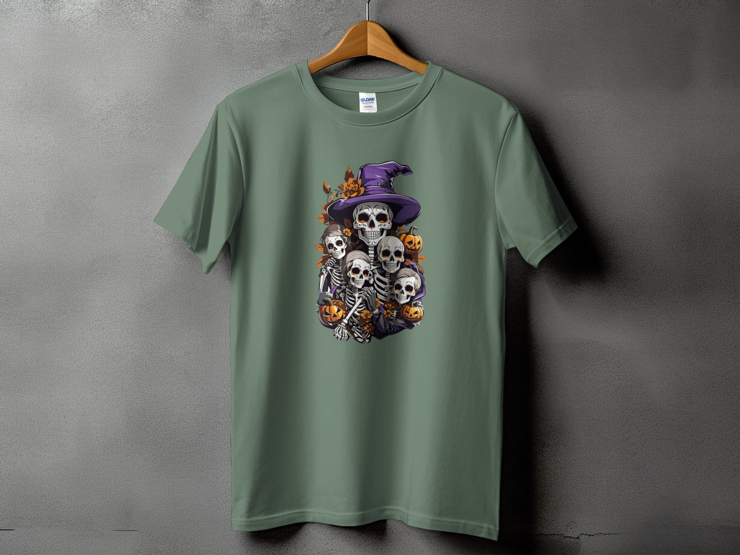 Green t-shirt with a Halloween graphic of skeletons and pumpkins wearing a witch hat.