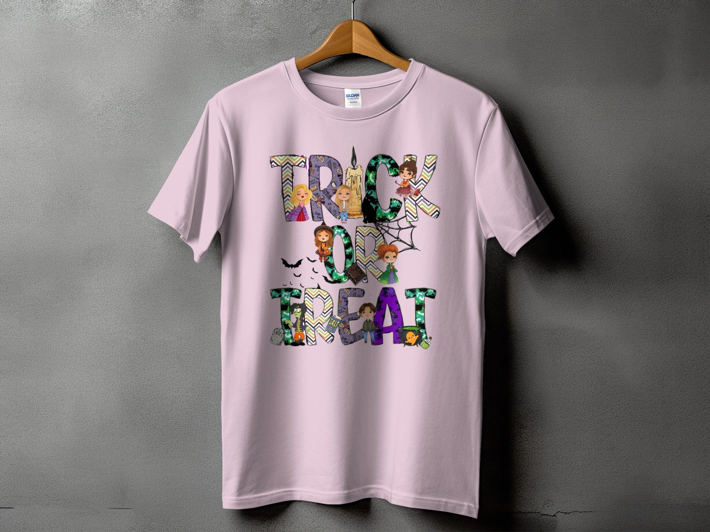 Pink t-shirt with "Trick or Treat" text featuring Halloween characters and spiderwebs.