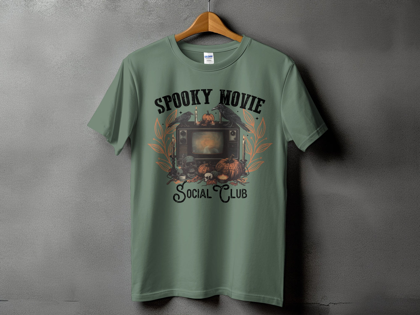 Green t-shirt with a vintage TV graphic, pumpkins, crows, and text "Spooky Movie Social Club".