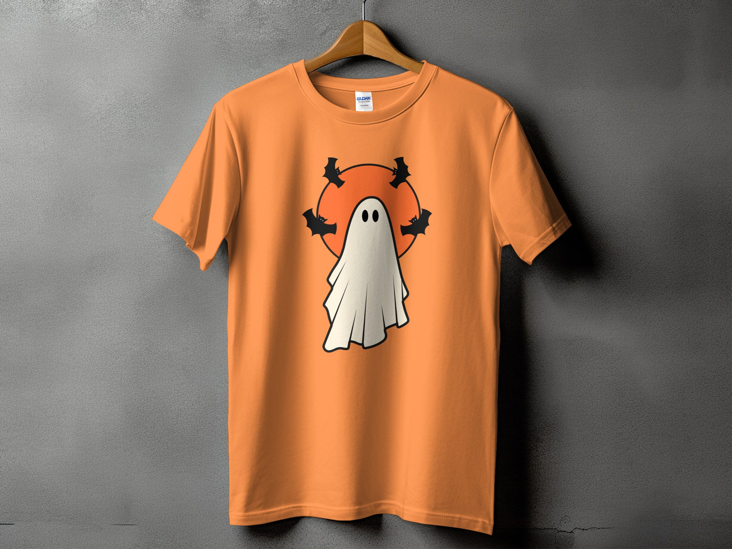 Orange t-shirt with a white ghost and bats on an orange circle.