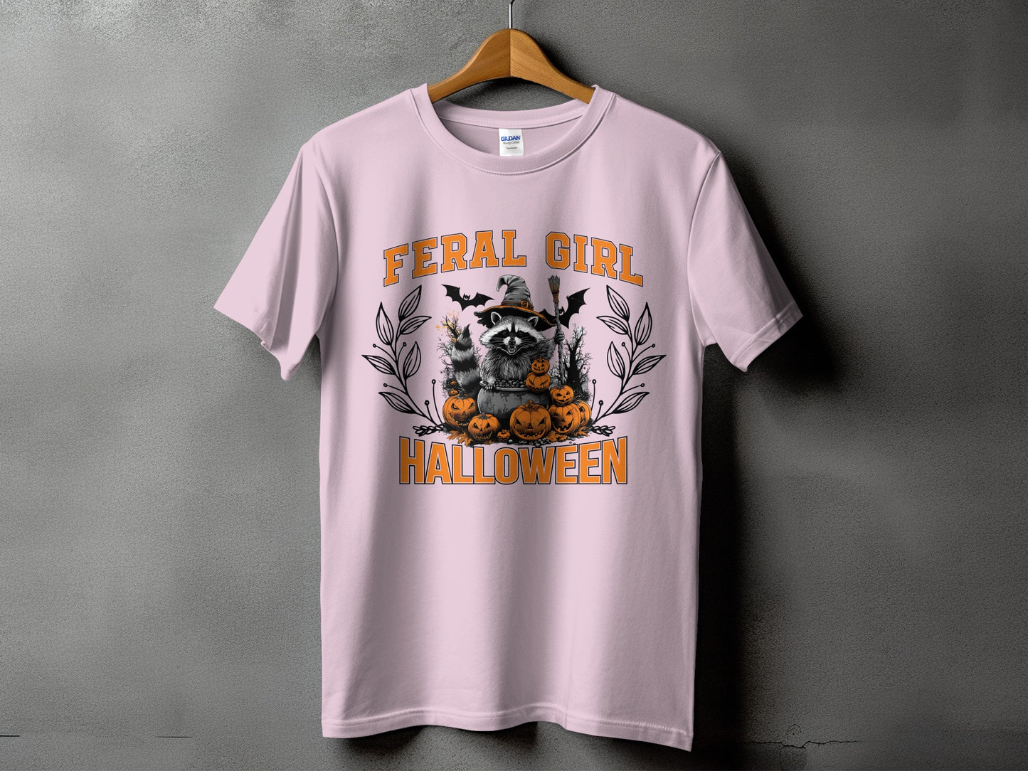 Light pink t-shirt with "FERAL GIRL HALLOWEEN" graphic featuring a raccoon and pumpkins.
