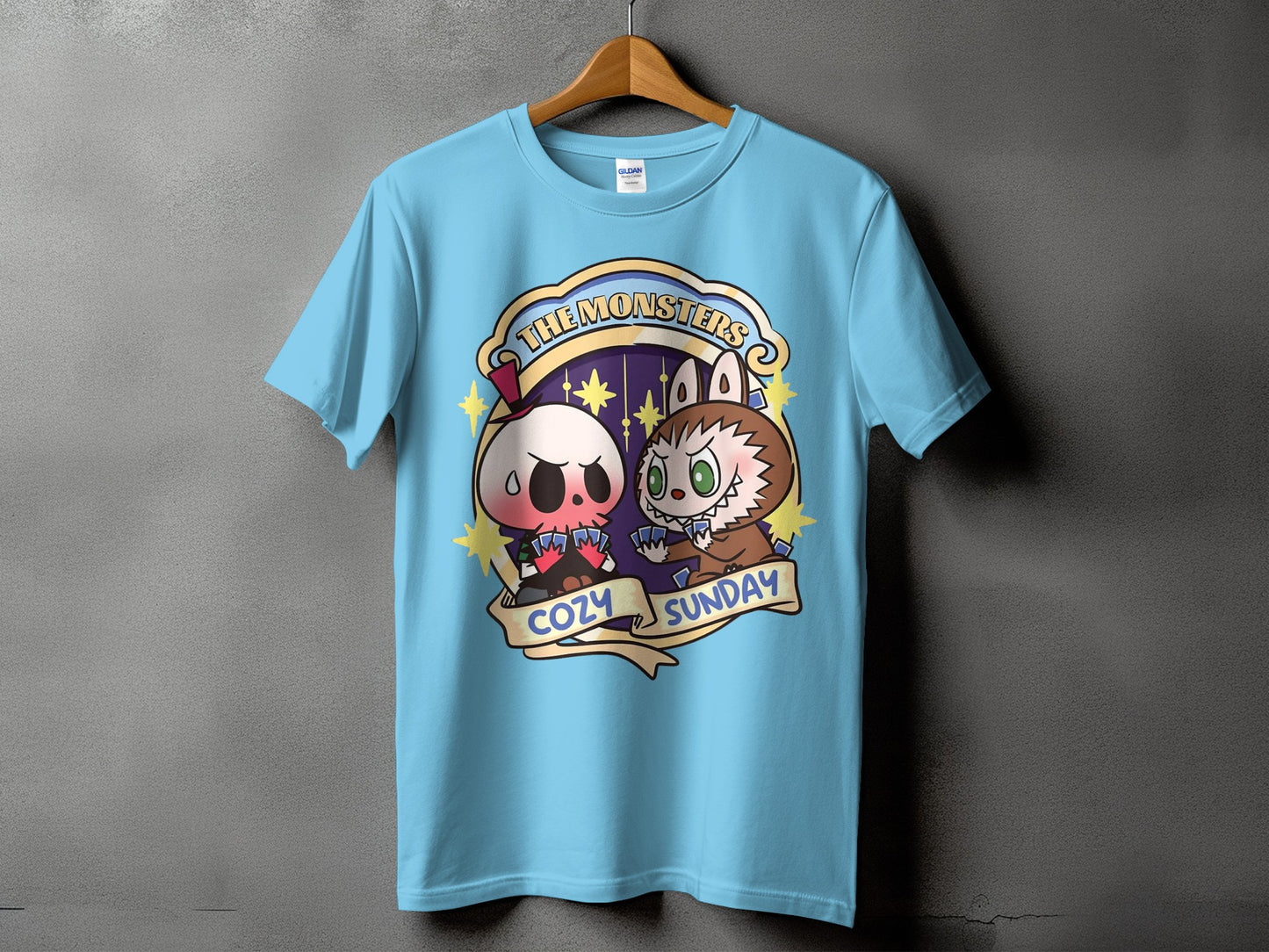 Light blue t-shirt with "The Monsters Cozy Sunday" graphic featuring cute monster characters.