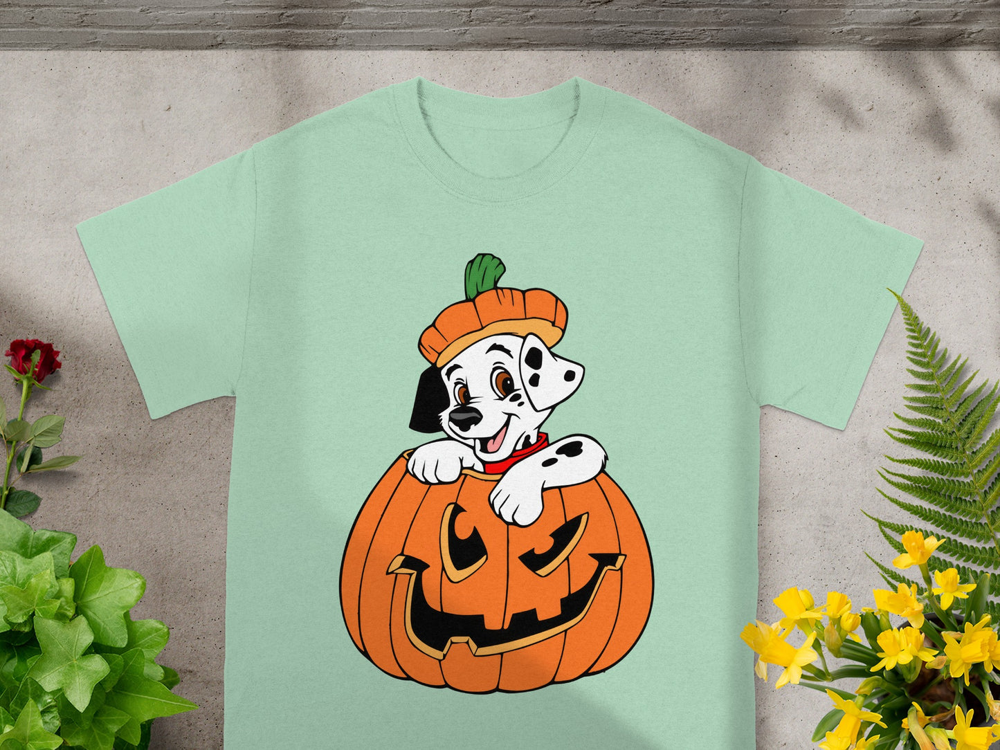 Dalmatian puppy wearing a pumpkin hat peeks out of a jack-o'-lantern.