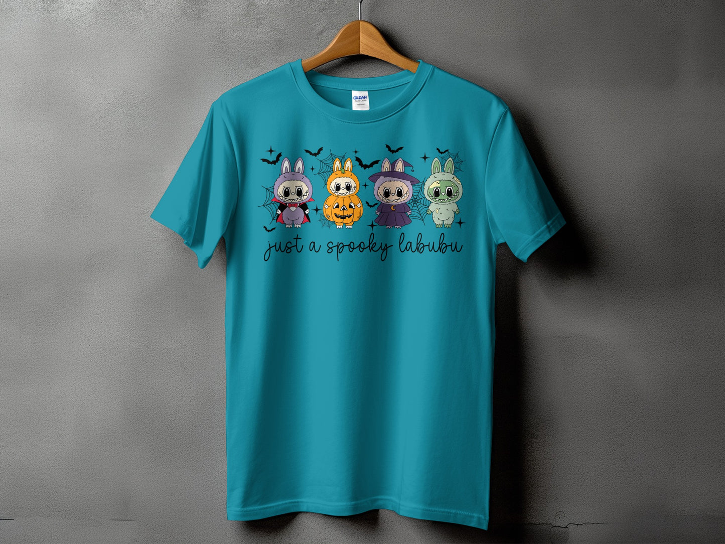 Teal t-shirt with four Halloween-themed cartoon characters and text that reads "just a spooky labubu".